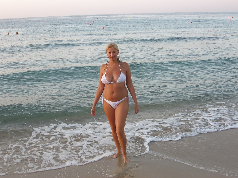 Зрелая блондинка с большими дойками загорает на море фото
