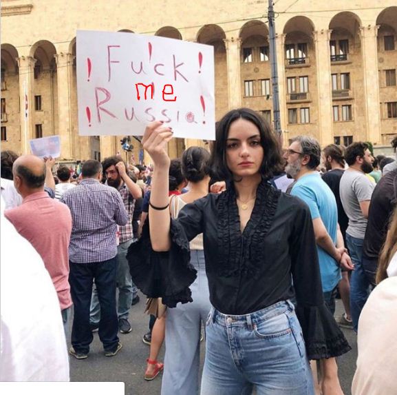 Установлена личность девушки из Тбилиси с оскорбительным плакатом в адрес России
