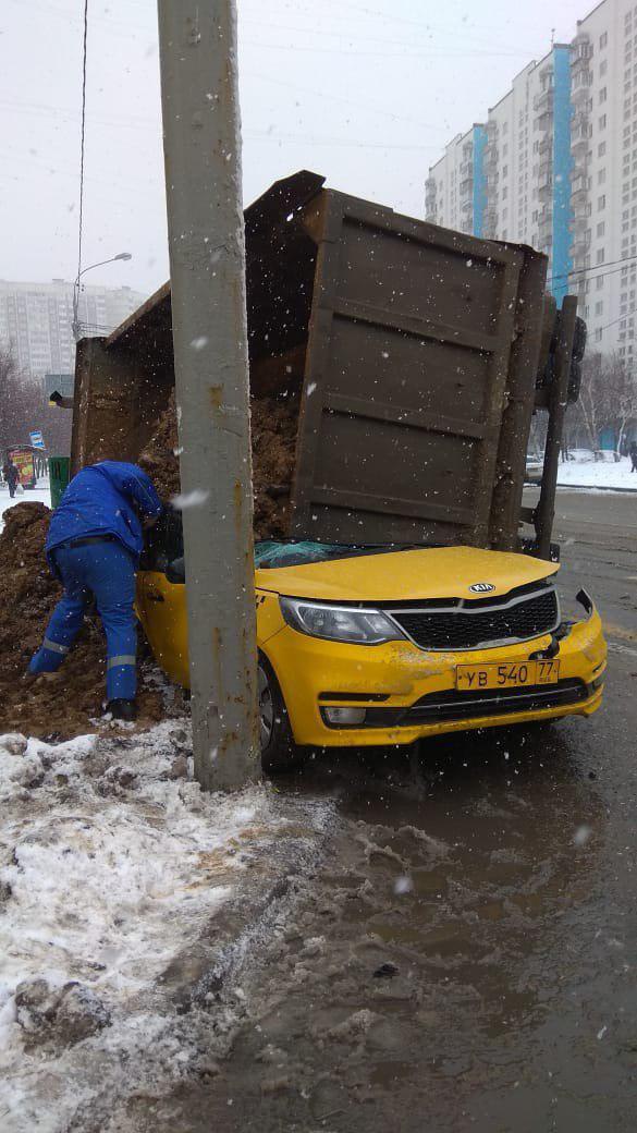 В Москве многотонный грузовик с землей занесло после аварии, и он опрокинулся прямо на такси