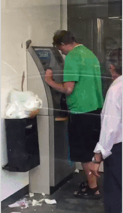 Немного уставший мужчина у банкомата