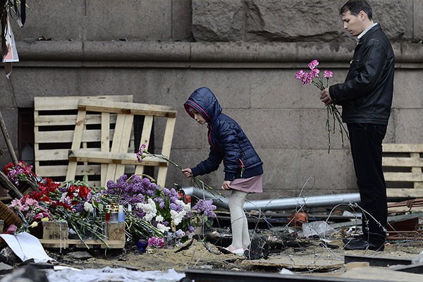 Отец и дочь возлагают цветы в память погибшим от фашистов