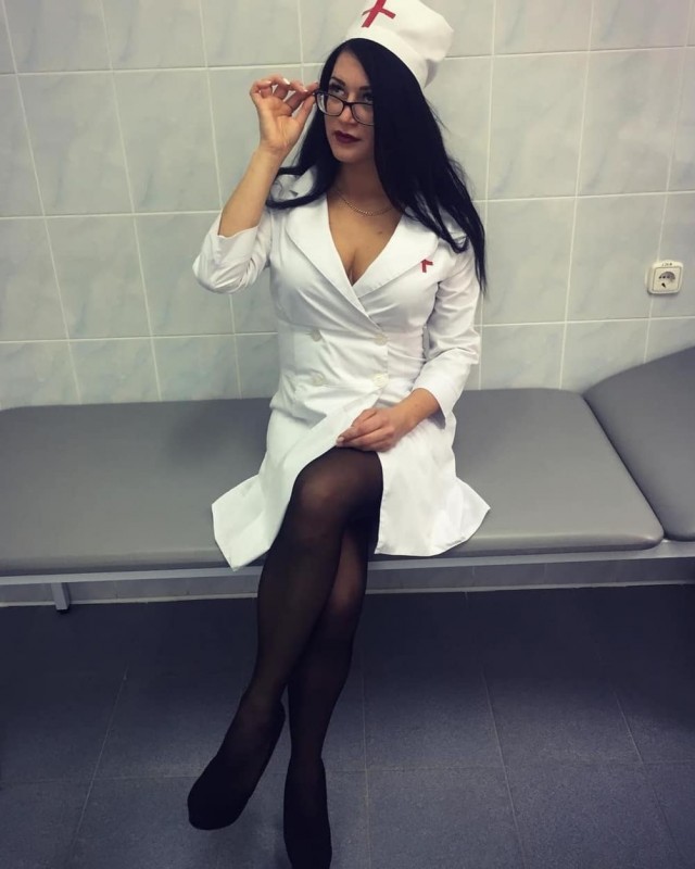 Брюнетка в красном платье работает медсестрой