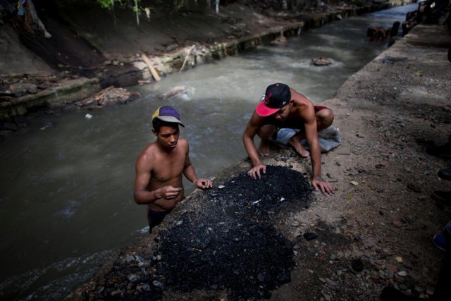 Молодые венесуэльцы ищут металл в реке, чтобы хоть как-то выживать