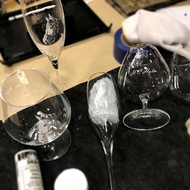 Процесс гравировки пескоструем на бокале шампанского