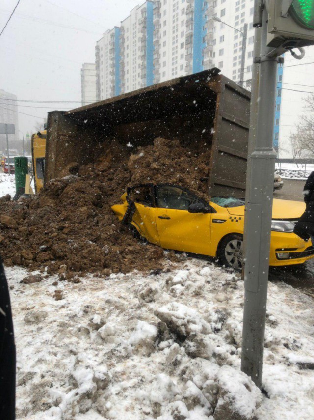 В Москве многотонный грузовик с землей занесло после аварии, и он опрокинулся прямо на такси