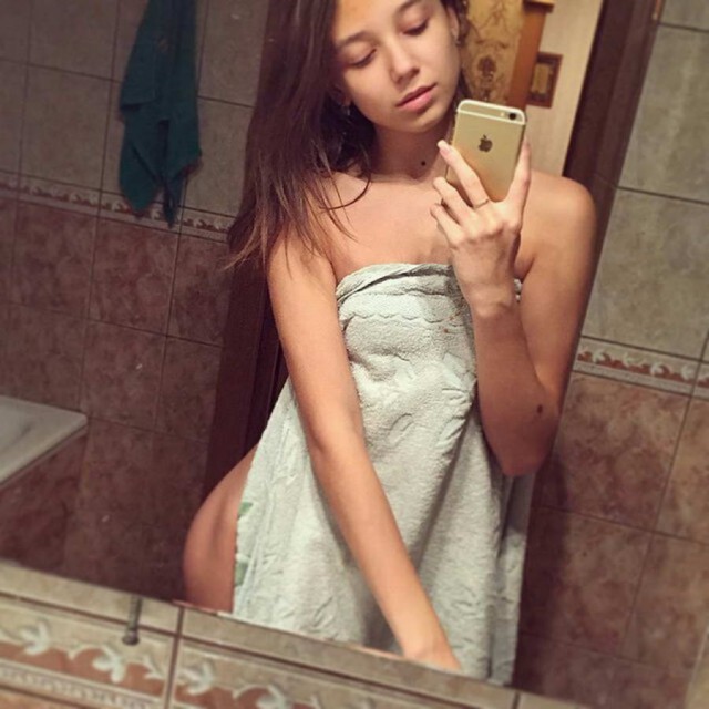 Молодая девушка в ванной вытерла себя полотенцем