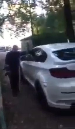 Сотрудник ДПС пытается разбить стекло BMW X6