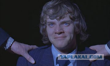 Девочка кидает монетку уличному музыканту.