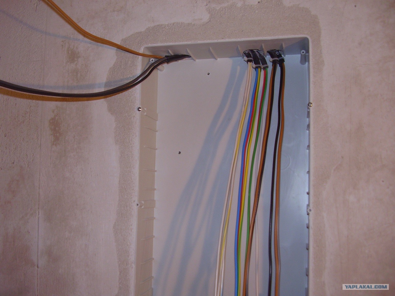 Проводка электропроводка. Расключение электрического щитка. Вводной кабель в квартиру. Провода на стене. Укладка кабеля в щитке.