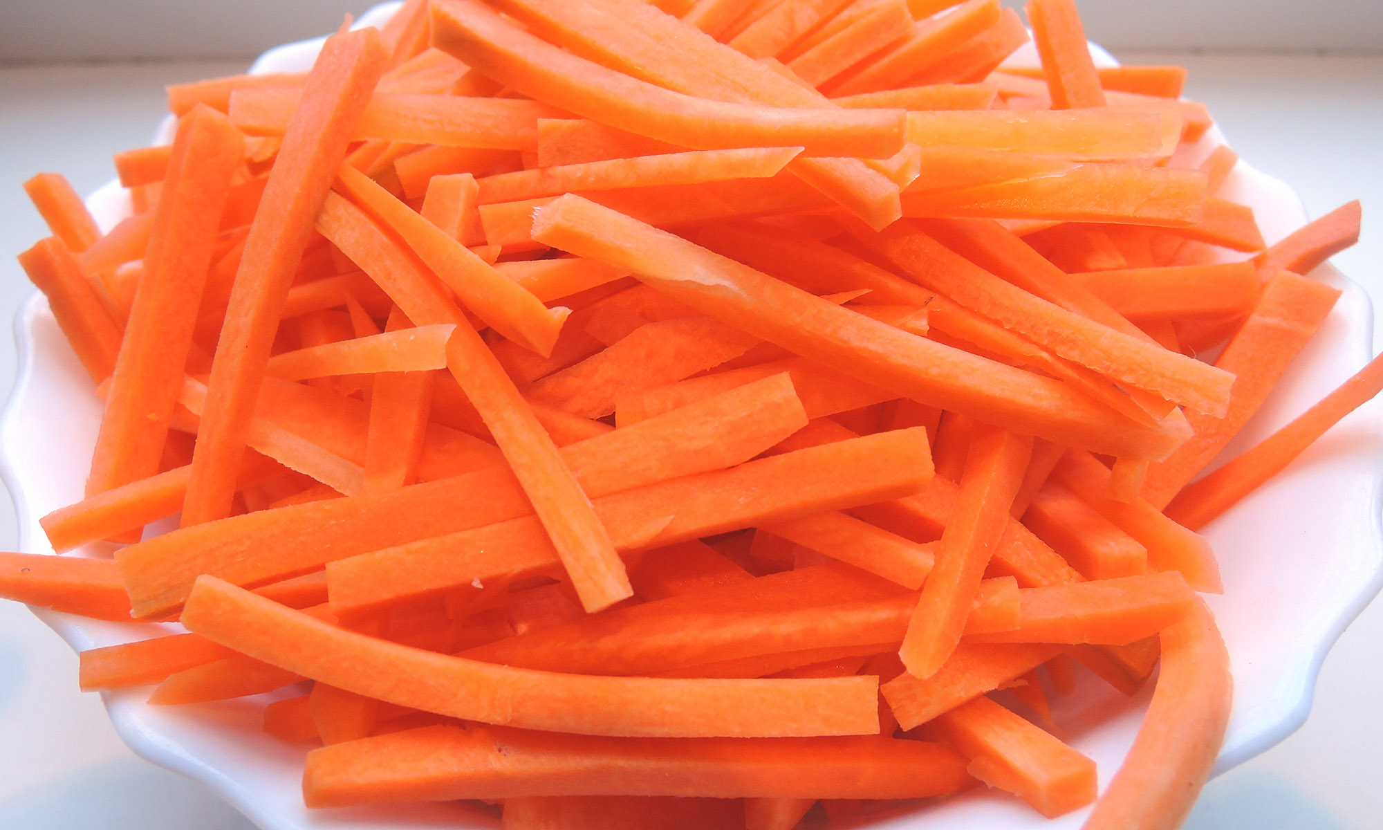 Нарезка овощей соломкой. Морковь резаная. Морковь нарезанная соломкой. Морковь резаная палочки. Морковь соломкой в тарелке.