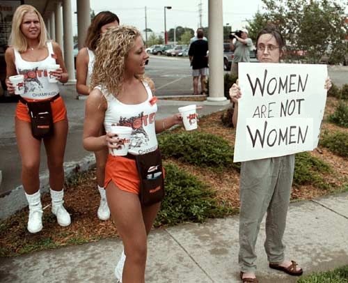 Официантки ресторана Hooters выносят воду протестующим феминисткам. США, 2000-е