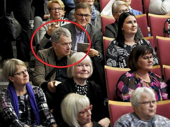Президент Финляндии сидит на ступеньках аудитории