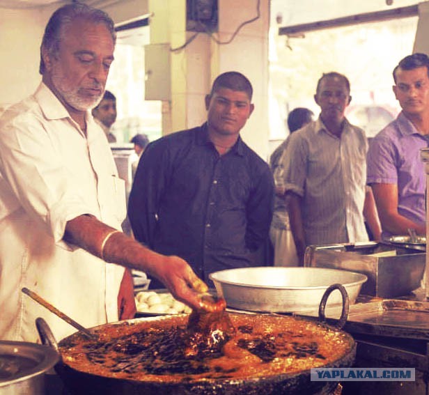 Индийский повар окунает руки в кипящее масло