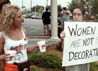 Официантки ресторана Hooters выносят воду протестующим феминисткам. США, 2000-е