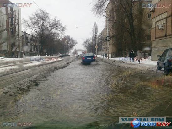 Уборщица поливает водой ступени около входа