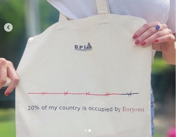 Установлена личность девушки из Тбилиси с оскорбительным плакатом в адрес России