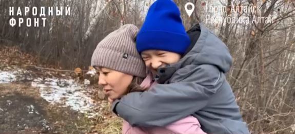 В Горно-Алтайске мать ребенка-инвалида носит его на спине в гору из-за разбитой дороги
