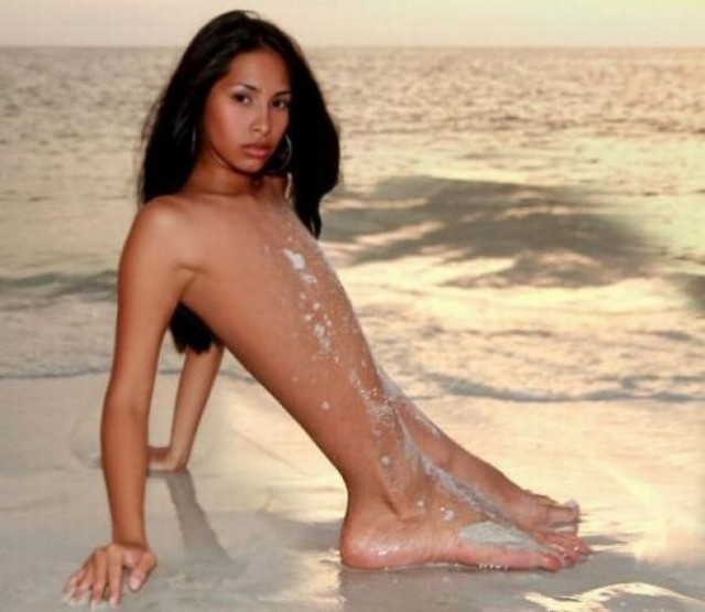 Секси-девочка на пляже в лучах заката