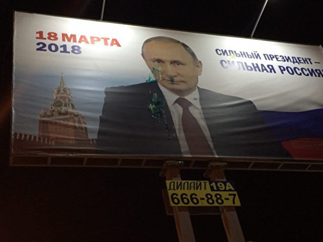 Пожарные моют баннер Путина, а полицейские охраняют