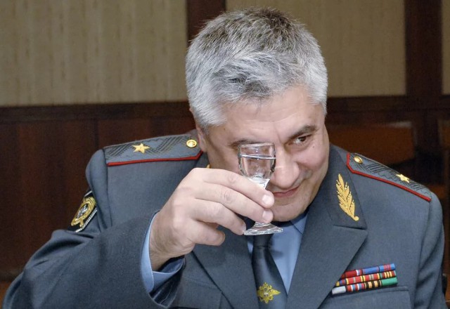 Целая группа полицейских собралась, чтобы придумать повод для задержания одного человека с плакатом по поводу пенсионной реформы