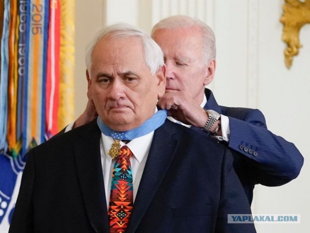 Новая реальность США. Джо Байден вешает мужику медаль на спину.