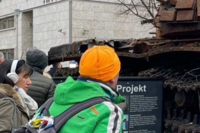 Люди в Берлине несут цветы к российскому танку