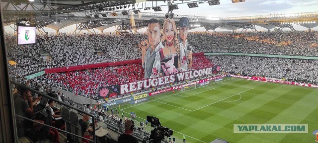 «Беженцы, добро пожаловать». Фанаты «Легии» вывесили баннер c изображением женщины с головой поросенка в руках и двух мужчин.