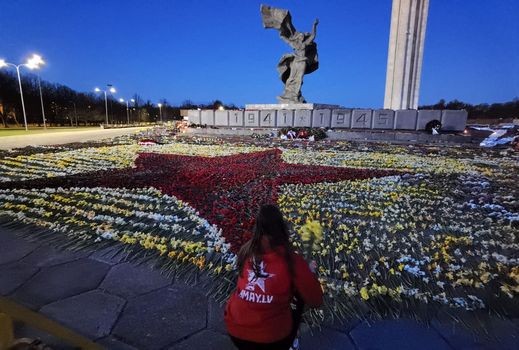 Латвийская молодежь ночью выложила ковер из цветов около памятника освободителям Риги