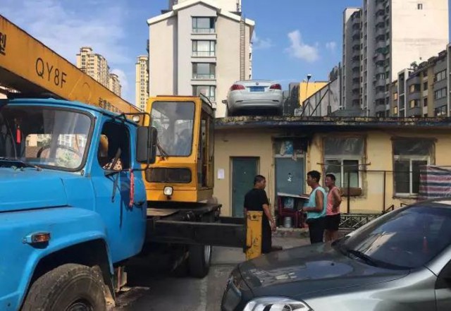 В Китае припаркованную в неположенном месте машину эвакуировали на крышу дома