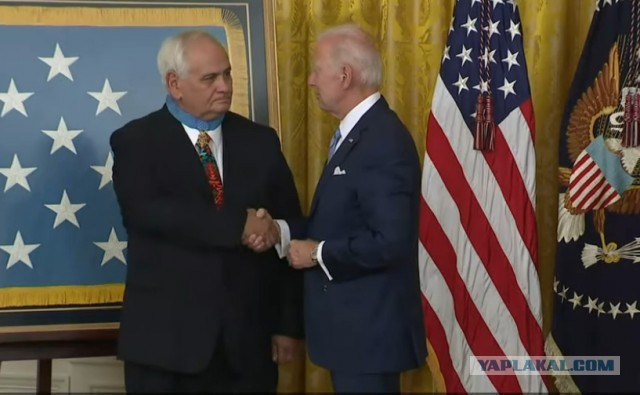 Новая реальность США. Джо Байден вешает мужику медаль на спину.
