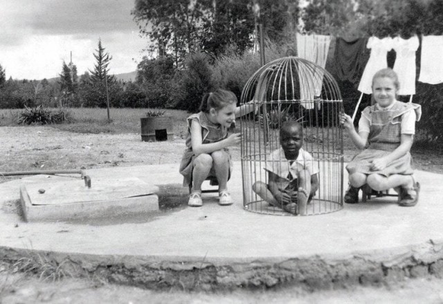 Бельгийские девочки играют с негритёнком в клетке для птиц, 1955 год.