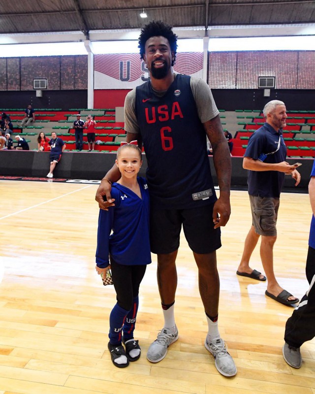 Олимпийская гимнастка позирует с баскетболистом.