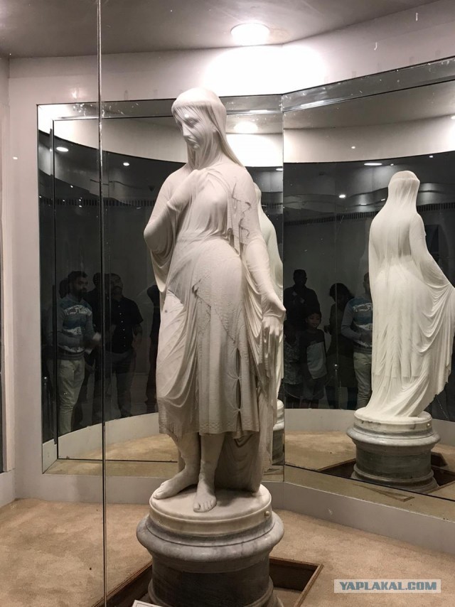 Стоит статуя посреди заката а место уя большая лопата...