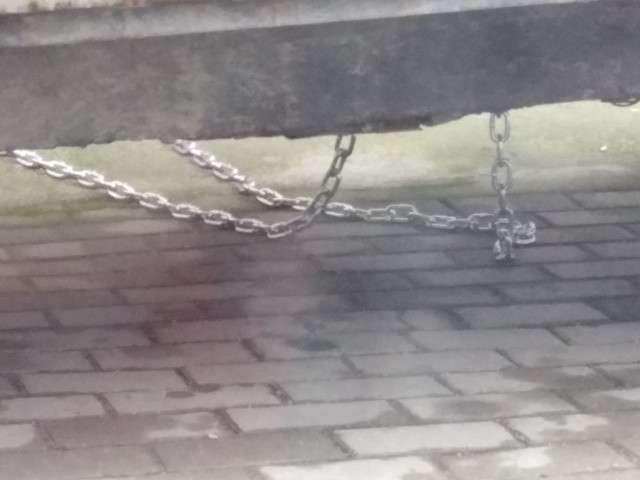 В Калининграде мужик припарковался на тротуаре, и чтобы его авто не эвакуировали, приковал машину цепями к дому