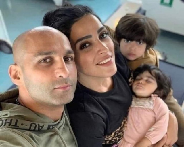 Боксер Ахмад Ширази и его жена делают семейное фото, на котором его жена без хиджаба