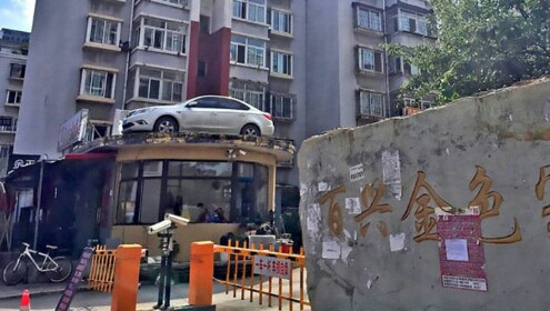 В Китае припаркованную в неположенном месте машину эвакуировали на крышу дома