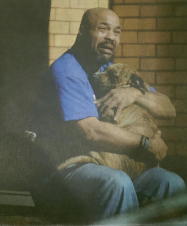 Мужчина держит свою собаку