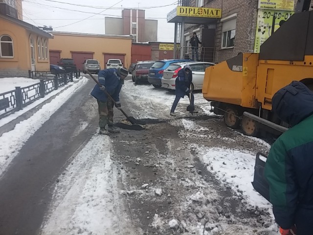В Одинцово рабочие кладут асфальт на мокрую тротуарную плитку