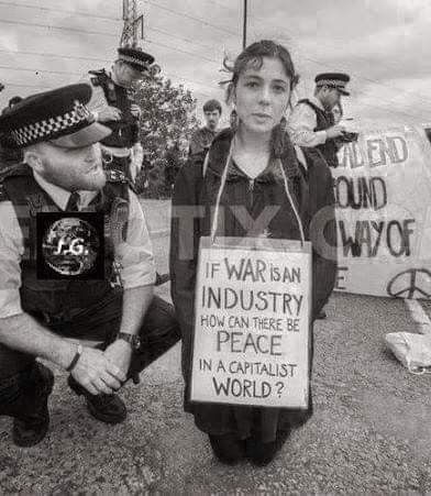 Старое фото. Надпись на плакате у пикетчицы: "Если война является индустрией, то как возможен мир при капиталистическом строе?"