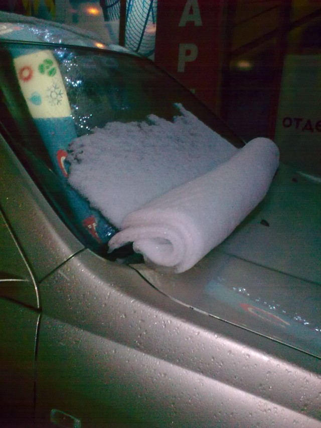 Снег в скатку на лобовом стекле авто
