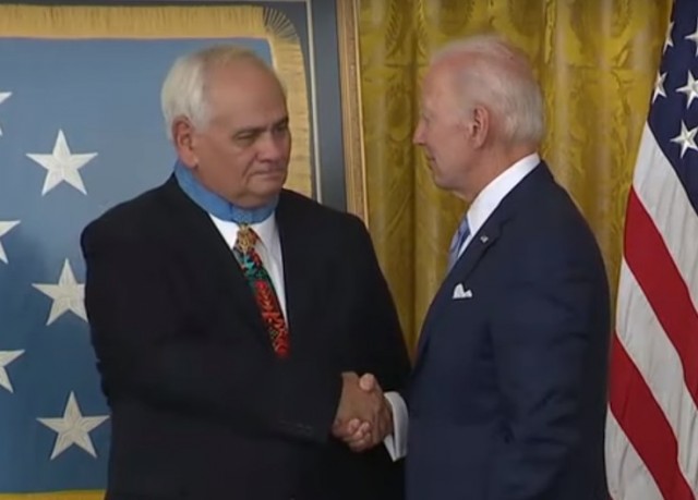 Новая реальность США. Джо Байден вешает мужику медаль на спину.