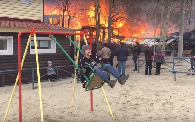Ничего необычного... Ребёнок на качелях на фоне пожара в Люберцах