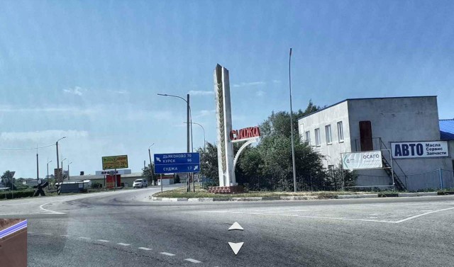 Российские солдаты фотографируются на фоне въезда в Суджу