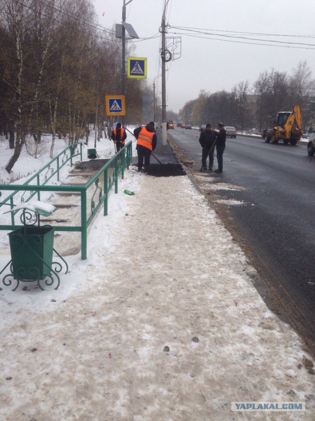 В Одинцово рабочие кладут асфальт на мокрую тротуарную плитку