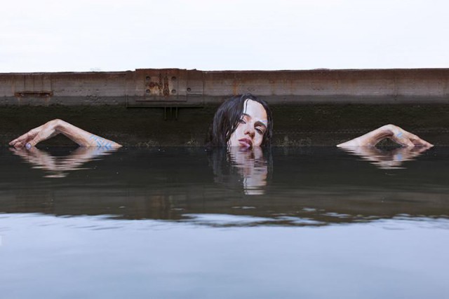 Художник рисует потрясающие картины у воды, стоя на доске для серфинга
