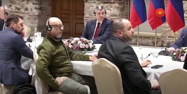 На переговорах, но уже без шапки