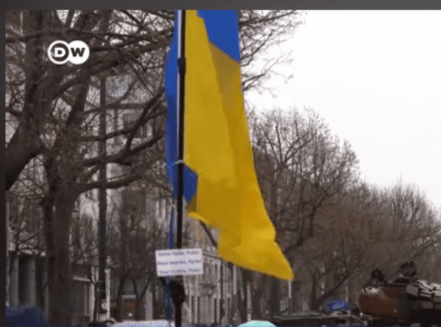 Люди в Берлине несут цветы к российскому танку